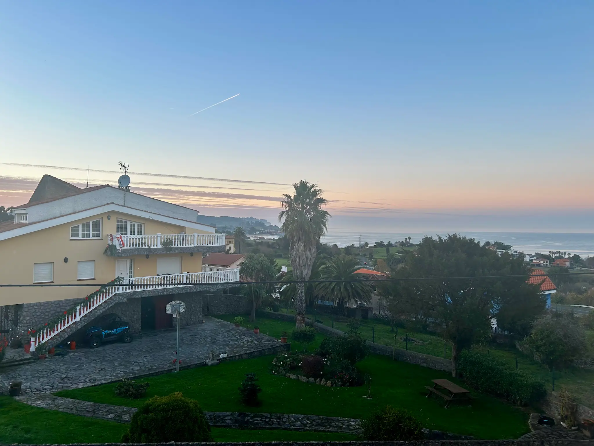 Atardecer en Duesos Asturias con casa rural, jardín y vistas al mar Cantábrico desde una terraza